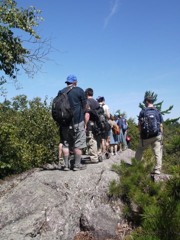 Hikers lined up on outcrop, Jeremy Glick Trail, Abram S. Hewitt State Park, NJ