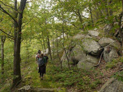 Hikers pass by rock formations on the Fishkill Ridge Trail